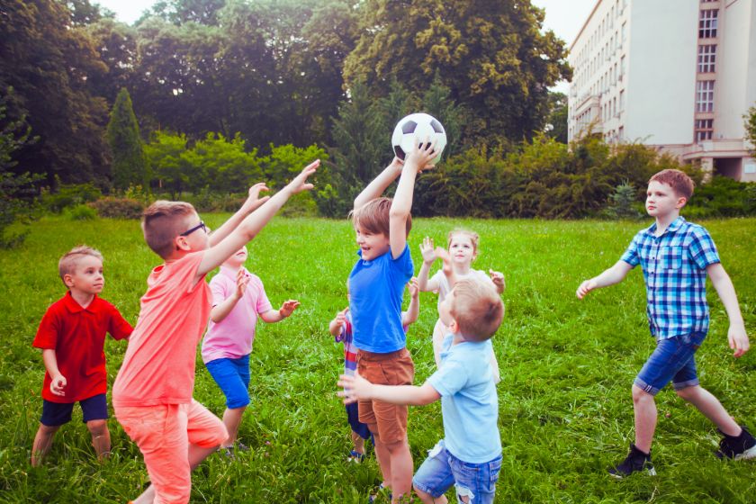 Die Jungs auf dem Bild spielen mit einem Ball. 